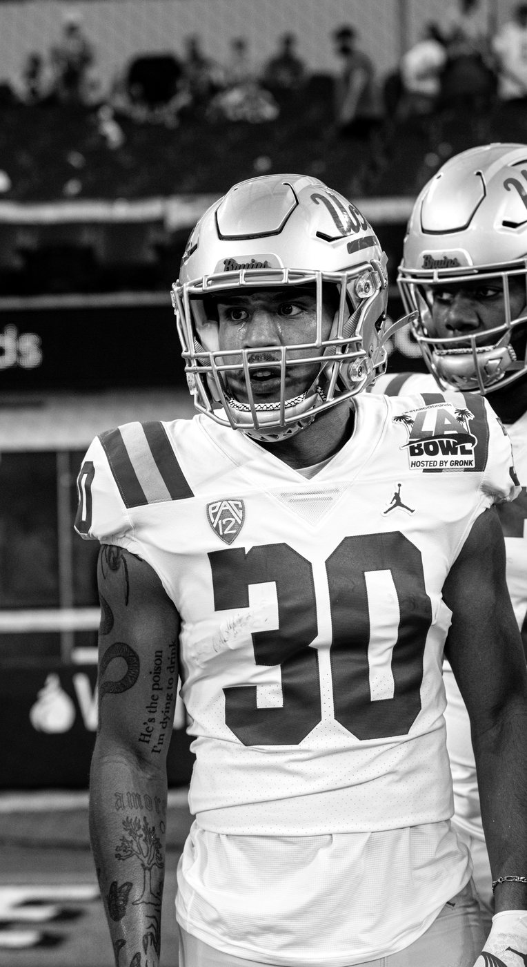 Minaya Olivo on the sideline in UCLA football uniform, number 30